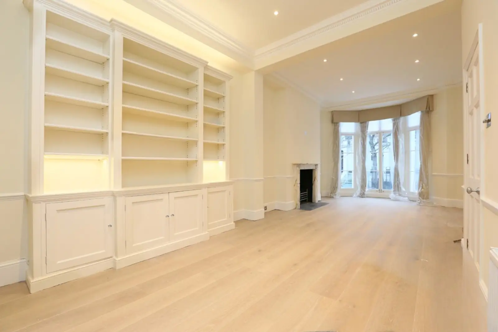 Reception room with painted built-in shelving and oak floor
