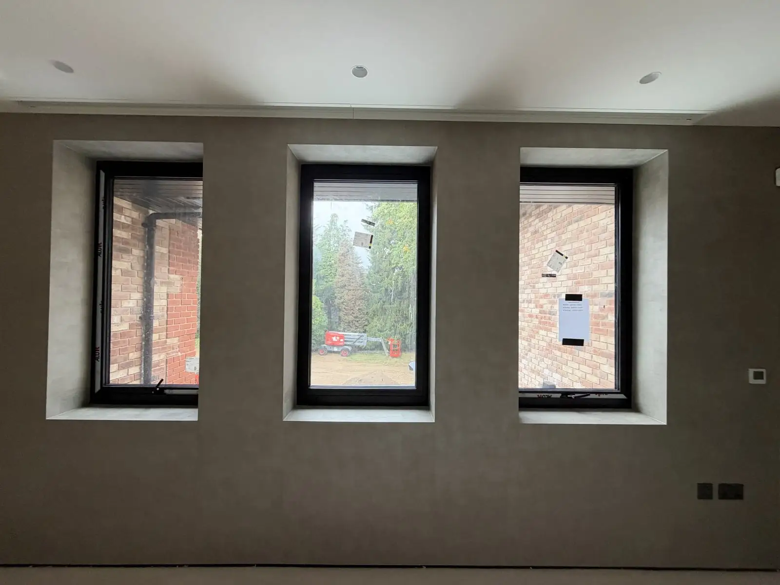 New-build lounge with three windows and a textured feature wall